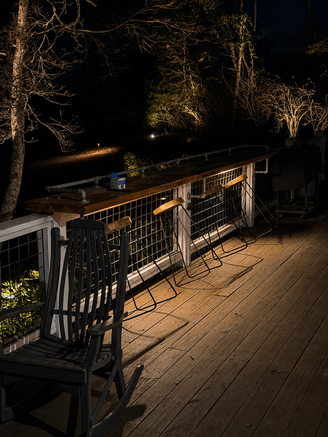 Elevated deck with under-rail accent lighting and landscape