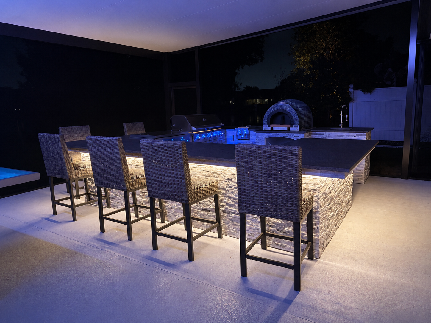 Contemporary pool patio with neon linear accent lighting