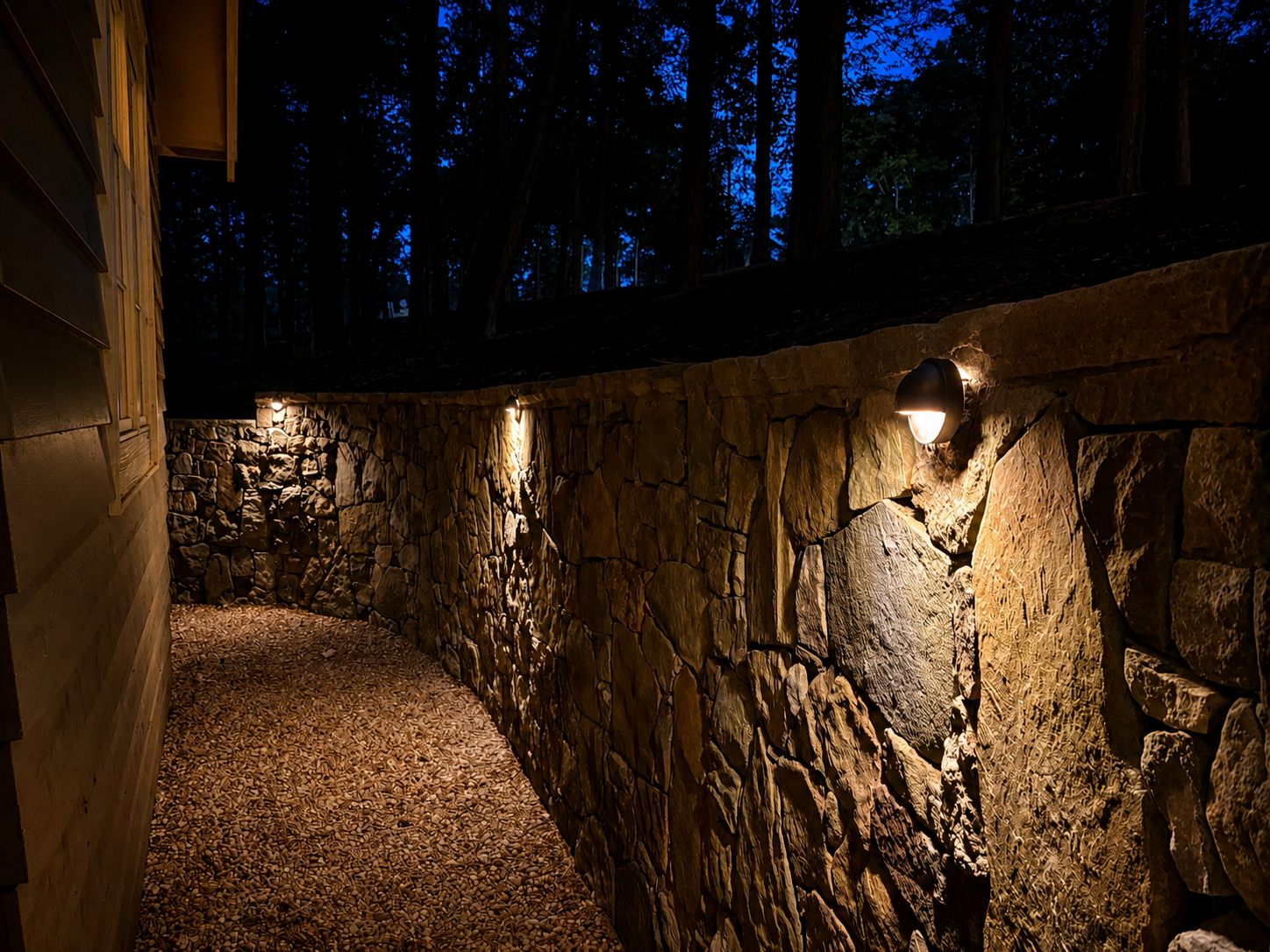 Stone retaining wall with wall sconce accent lighting
